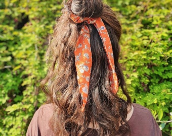 Duurzaam handgemaakte bow scrunchie in dunne oranje stof met bloemenprint, voelt aan als viscose, zijde , gemaakt van reststof. Koningsdag!