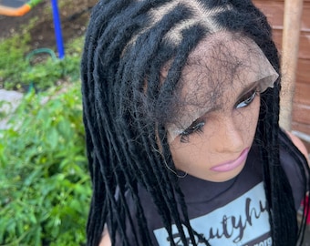Könnte beinhalten: Eine schwarze Dreadlock-Perücke mit Spitzenfront wird auf einem Schaufensterkopf gezeigt. Die Perücke hat einzelne Dreadlocks und einen natürlich aussehenden Haaransatz. Die Schaufensterpuppe trägt ein schwarzes T-Shirt mit dem Text "Beautyhub".