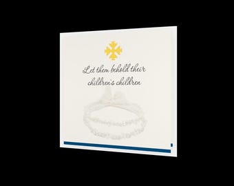 May include: A cream-colored card with the text "Let them behold their children's children" and a decorative garter image. A gold cross is at the top. A blue stripe accents the bottom.