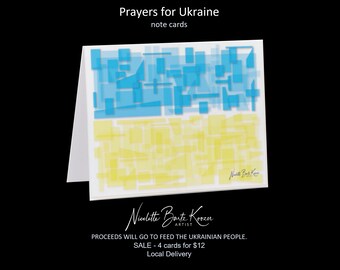 May include: Note cards with the text "Prayers for Ukraine" and a design in the colors of the Ukrainian flag. The design is abstract, with blue and yellow geometric shapes. The artist's signature is visible.