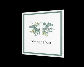 May include: Square white card with a light green border. The card features a white cross surrounded by green leaves and a floral design. The Greek text "Na sas zesei!" is printed below the cross.