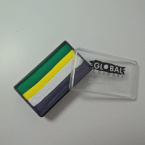 Può includere: Palette rettangolare di trucchi per il viso con strisce verdi, gialle, bianche e blu navy. La palette è in una cornice nera e un coperchio di plastica trasparente con la scritta "GLOBAL COLOURS" la copre parzialmente. Sono visibili anche le parole "Beginner's Collection".