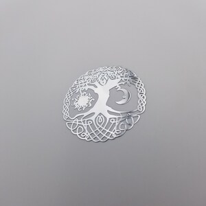 May include: Silver-toned metal tree of life pendant with a sun and moon design. The tree is intricately detailed with a Celtic knot border.