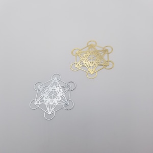 May include: Two geometric metal shapes, one gold and one silver, with intricate designs. The shapes are similar and resemble a star of David.