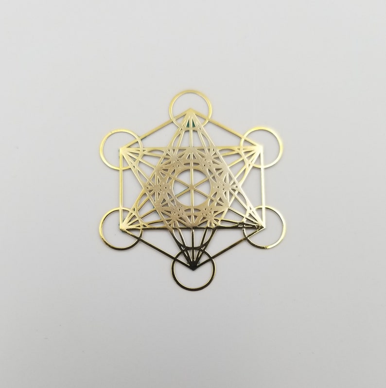 May include: Gold-colored metal geometric design with a circular pattern in the center. The design is a combination of squares, triangles, and circles.