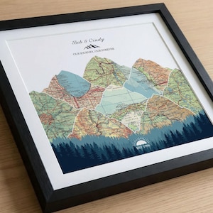 May include: Framed artwork featuring mountain silhouettes crafted from vintage map fragments. The artwork includes the text "Bob & Cindy, Our Journey, Our Forever" and "EST 1996". The mountains are set against a blue forest and white background.