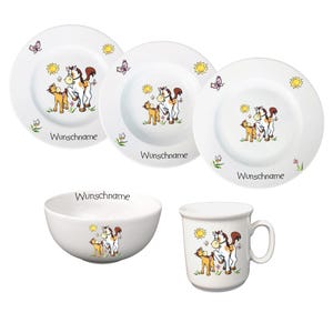 Könnte beinhalten: Ein weißes Kindergeschirr-Set aus Keramik mit einem Pferde- und Fohlenmotiv. Das Set beinhaltet eine Schüssel, eine Tasse und zwei Teller. Die Teller haben eine Sonne, Schmetterlinge und Blumen am Rand. Der Text "Wunschname" ist auf jedes Stück gedruckt.