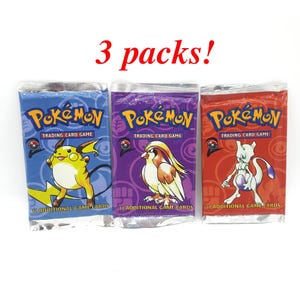 Peut inclure: Trois paquets scellés de cartes à collectionner Pokémon. Les paquets sont bleus, violets et rouges, chacun présentant un personnage Pokémon différent. Le texte "3 packs!" est au-dessus des paquets.