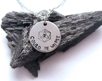 May include: Silver necklace with a round pendant that says "Could be worse" with a 20-sided die graphic in the centre.