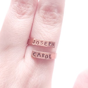 Peut inclure: Deux bagues dorées avec les noms "JOSEPH" et "CAROL" gravés dessus. Les bagues sont portées à un doigt.