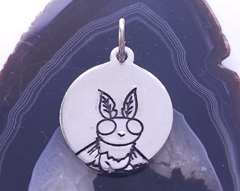 May include: A silver charm featuring a detailed engraving of a moth. The charm is round and has a loop at the top for attaching to a necklace or bracelet.