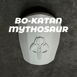 May include: A white 3D printed model of the Mandalorian's Mythosaur skull with the text "Bo-Katan Mythosaur" above it.
