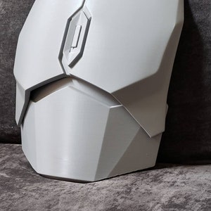 Puede incluir: Una pieza de pecho de pl&aacute;stico blanco con un dise&ntilde;o geom&eacute;trico. La pieza de pecho tiene un panel rectangular elevado en el centro.