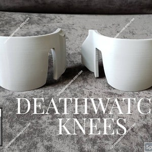 May include: A pair of white 3D printed knee pads with a textured surface. The knee pads are labeled "DEATHWATCH KNEES".