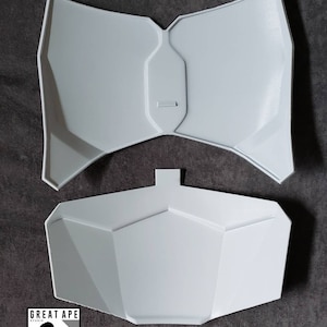 Puede incluir: Dos piezas de pl&aacute;stico blanco que forman una pieza de pecho para un disfraz. Las piezas tienen forma de pechera con la parte inferior puntiaguda y la superior redondeada. Las piezas est&aacute;n dise&ntilde;adas para unirse y formar una pieza de pecho completa.