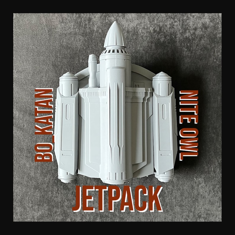 K&ouml;nnte beinhalten: Ein wei&szlig;es Plastikmodell eines Jetpacks mit den Worten "BO-KATAN" und "NITE OWL" an den Seiten und "JETPACK" unten.