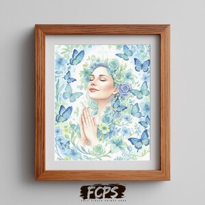 May include: A framed art print featuring a woman with closed eyes and hands clasped in prayer. She is surrounded by blue butterflies and floral elements in shades of blue and green. A cross is visible above her head. The frame is made of wood.
