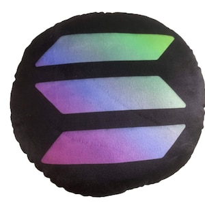 May include: A round black pillow with a colorful, iridescent design of three overlapping chevron shapes.