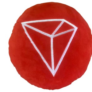 May include: Red round pillow with a white embroidered diamond shape in the center.