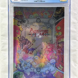 May include: A graded comic book of Adventure Time #1, featuring a colorful illustration with characters from the animated series. The cover art includes the title, issue number, and artist credits. The comic is encased in a protective holder with a 9.4 grade.