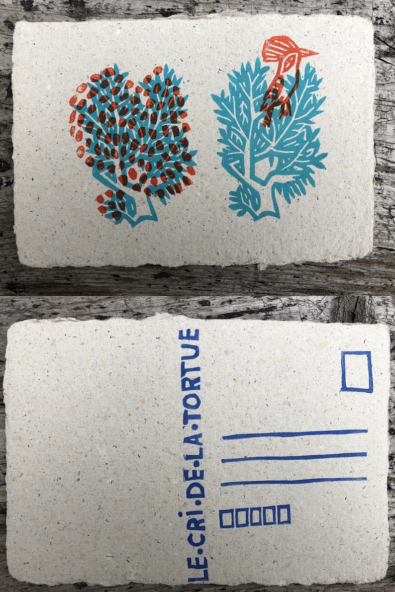 Puede incluir: Una postal con una ilustraci&oacute;n azul y naranja de un p&aacute;jaro en una rama de &aacute;rbol. La postal tiene un sello azul y el texto "LE CRI DE LA TORTUE" impreso en el lado izquierdo.