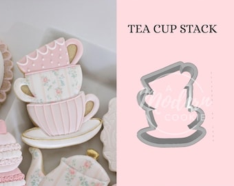 Puede incluir: Un archivo STL de cortador de galletas con forma de pila de tazas de té con el texto COOKIE CUTTER STL FILE, TEA CUP STACK e INSTANT DOWNLOAD. La imagen muestra una galleta terminada con forma de pila de tres tazas de té con glaseado rosa y floral.