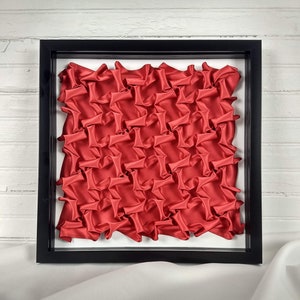 Red Half-Expanded Bars framed lattice smocking wall art, geometric fabric manipulation, 3D symmetric origami tessellation, textile art