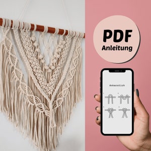 May include: Cream-colored macrame wall hanging with a wooden dowel. The design features intricate knotting patterns and fringe. A phone displays knotting instructions. A pink circle with the text "PDF Anleitung" is also visible.