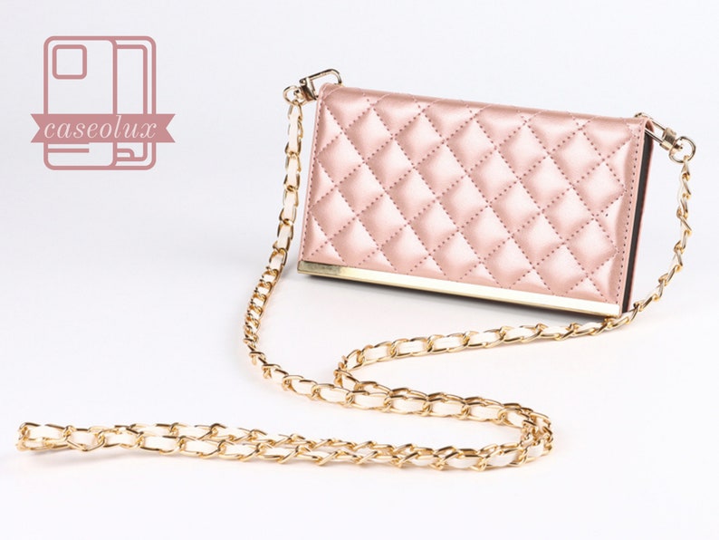 Puede incluir: Una funda de tel&eacute;fono acolchada rosa con una correa de cadena dorada. La funda tiene un patr&oacute;n de diamantes y un marco dorado. La cadena tambi&eacute;n es dorada. El logotipo "caseolux" est&aacute; en la esquina superior izquierda.