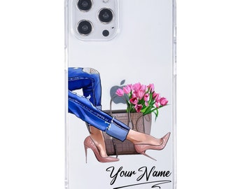Op de afbeelding: Transparante telefoonhoes met een mode-illustratie. Het ontwerp toont de benen van een persoon in een blauwe jeans en roze hoge hakken, met een handtas en roze tulpen. De tekst "Your Name" is cursief geschreven.