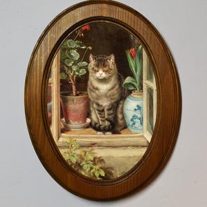 May include: A framed painting depicting a tabby cat sitting on a windowsill with a potted plant and a vase of flowers. The cat has its eyes closed and is looking at the viewer.