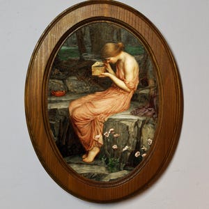 May include: A framed oil painting depicting a woman in a peach-coloured gown sitting on a rock, looking down at a small box in her hands. The background is a dark forest with a glimpse of a stream.