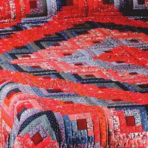 May include: A quilt featuring a log cabin pattern composed of numerous small fabric squares and rectangles. The design incorporates a vibrant colour palette of bright red, deep navy blue, and soft light blue, with various floral and geometric prints.