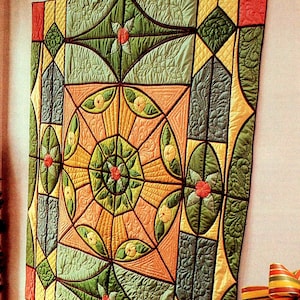 Puede incluir: Un edredón colorido con un diseño geométrico. El edredón presenta un patrón circular central con líneas radiales, rodeado de varias formas y motivos florales. La paleta de colores incluye tonos de verde, naranja, amarillo y rojo, creando un textil vibrante y llamativo.