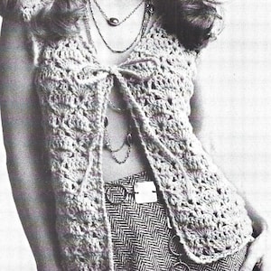 May include: A crocheted vest with a tie front and a delicate openwork pattern. The vest is made of a light-colored yarn and has a relaxed, flowy fit.