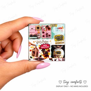 May include: A square Harry Potter Mini Verse Make It Mini Honeydukes craft kit box featuring colorful graphics of miniature candy, a birdcage, and a small round container. The packaging displays the text Harry Potter, Mini Verse, and New Nouveau.