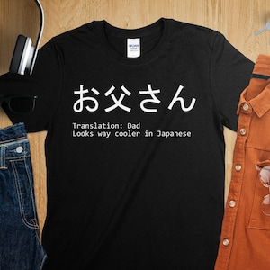 May include: Black t-shirt with white text that says "お  父  さ  ん" which translates to "Dad" and "Looks way cooler in Japanese".
