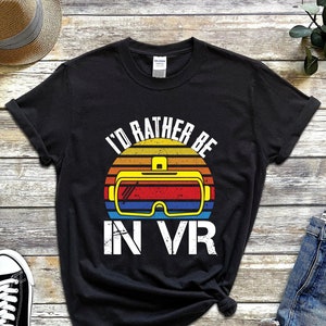 May include: Black t-shirt featuring a retro sunset graphic and the text "I'd rather be in VR" with a VR headset graphic.