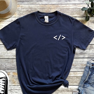 May include: A navy blue t-shirt with white angled brackets, "< />", printed on the front.