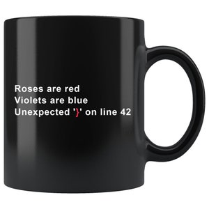 Op de afbeelding: Zwarte koffiemok met witte tekst die luidt "Roses are red, Violets are blue, Unexpected '}' on line 42".