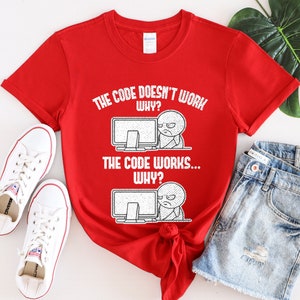 Peut inclure: T-shirt rouge avec du texte blanc qui dit "Le code ne fonctionne pas... Pourquoi ? Le code fonctionne... Pourquoi ?" Le texte est accompagn&eacute; d'une illustration de dessin anim&eacute; d'une personne devant un ordinateur.
