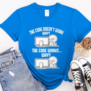 Peut inclure: Un t-shirt bleu avec un imprim&eacute; graphique blanc qui dit "The code doesn't work... Why? The code works... Why?" Le graphique repr&eacute;sente un personnage de dessin anim&eacute; avec un &eacute;cran d'ordinateur.