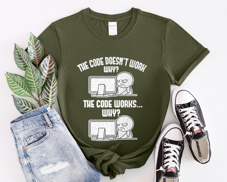Peut inclure: Un t-shirt vert avec un imprim&eacute; graphique blanc qui dit "Le code ne fonctionne pas... Pourquoi ?" et "Le code fonctionne... Pourquoi ?" avec une illustration de dessin anim&eacute; d'une personne devant un ordinateur.