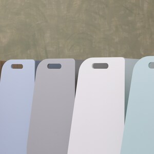 Pu&ograve; includere: Cinque contenitori di legno per la conservazione con bordi arrotondati e maniglie ritagliate. I contenitori sono di diversi colori: legno naturale, azzurro, grigio, bianco e azzurro.