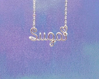 May include: Silver necklace with the name "Sugar" spelled out in wire with a heart at the end.