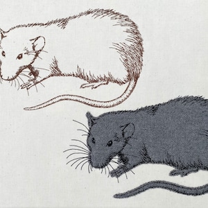 Könnte beinhalten: Zwei gestickte Bilder von Ratten, eine weiße und eine graue, auf einem weißen Stoffhintergrund.