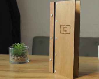 革ストラップに固定されたワインリスト用の木製メニューフォルダー