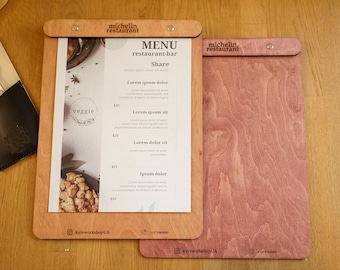 Könnte beinhalten: Zwei Holz-Menükarten, eine mit natürlicher Holzoptik und die andere mit einer rötlich-braunen Holzoptik. Die Menükarten auf der linken Seite hat ein gedrucktes Menü mit dem Text "michelin restaurant" und "MENU restaurant-bar". Die Menükarten auf der rechten Seite hat den Text "michelin restaurant" aufgedruckt.