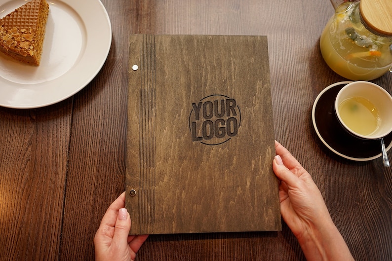 May include: A brown wooden menu cover with the text "YOUR LOGO" engraved in a circle on the front.