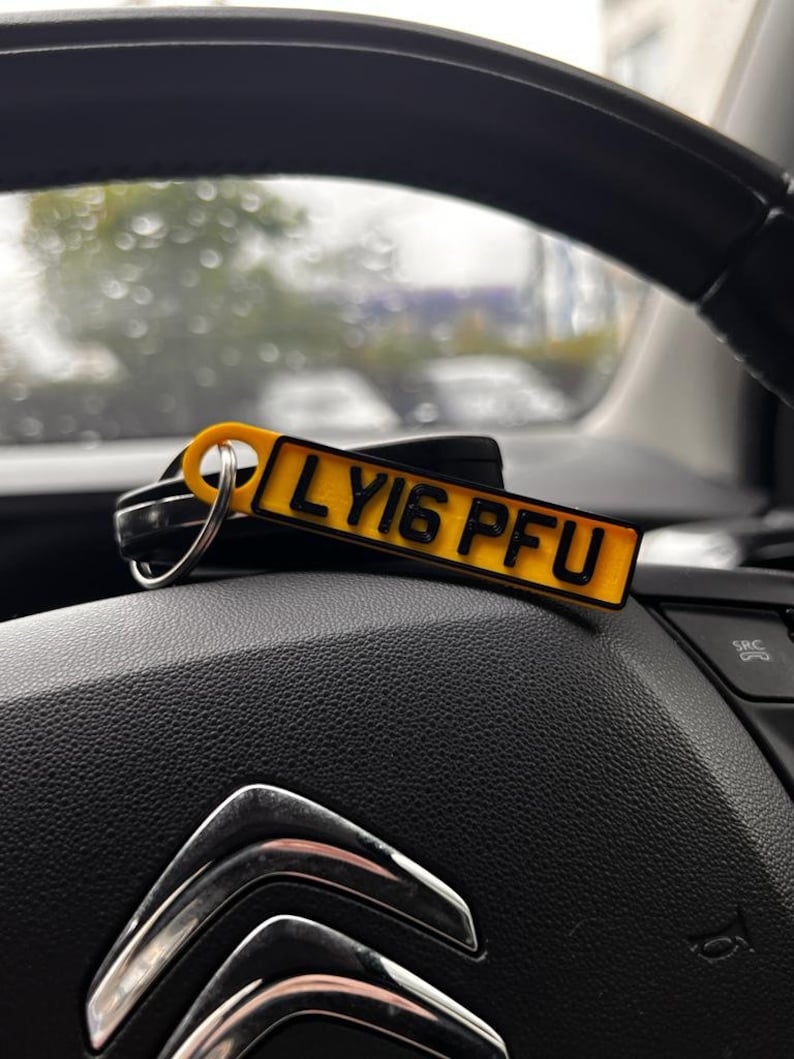 May include: A yellow car key chain with a black license plate that reads "LY16 PFU".